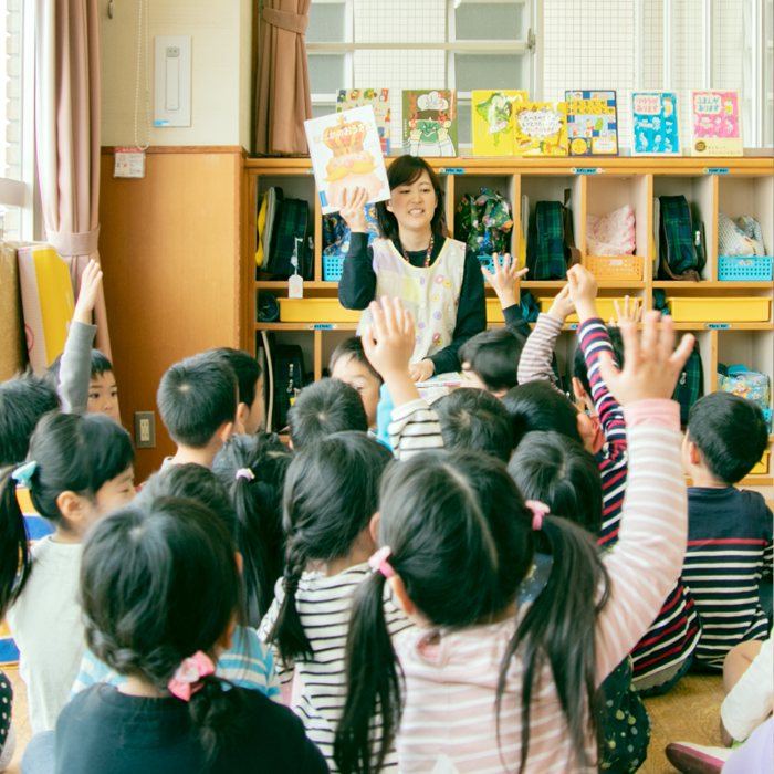 子どもたちに絵本の読み聞かせをしている保育士