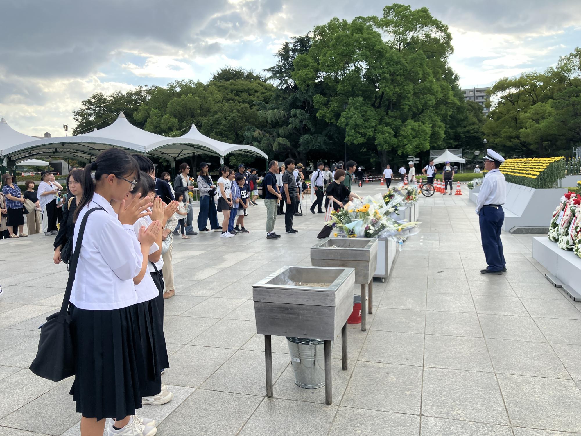 慰霊碑の前でお祈りをする生徒たち